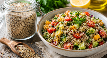 healthy quinoa salad beside a jar of raw quinoa grains in a rustic kitchen setting